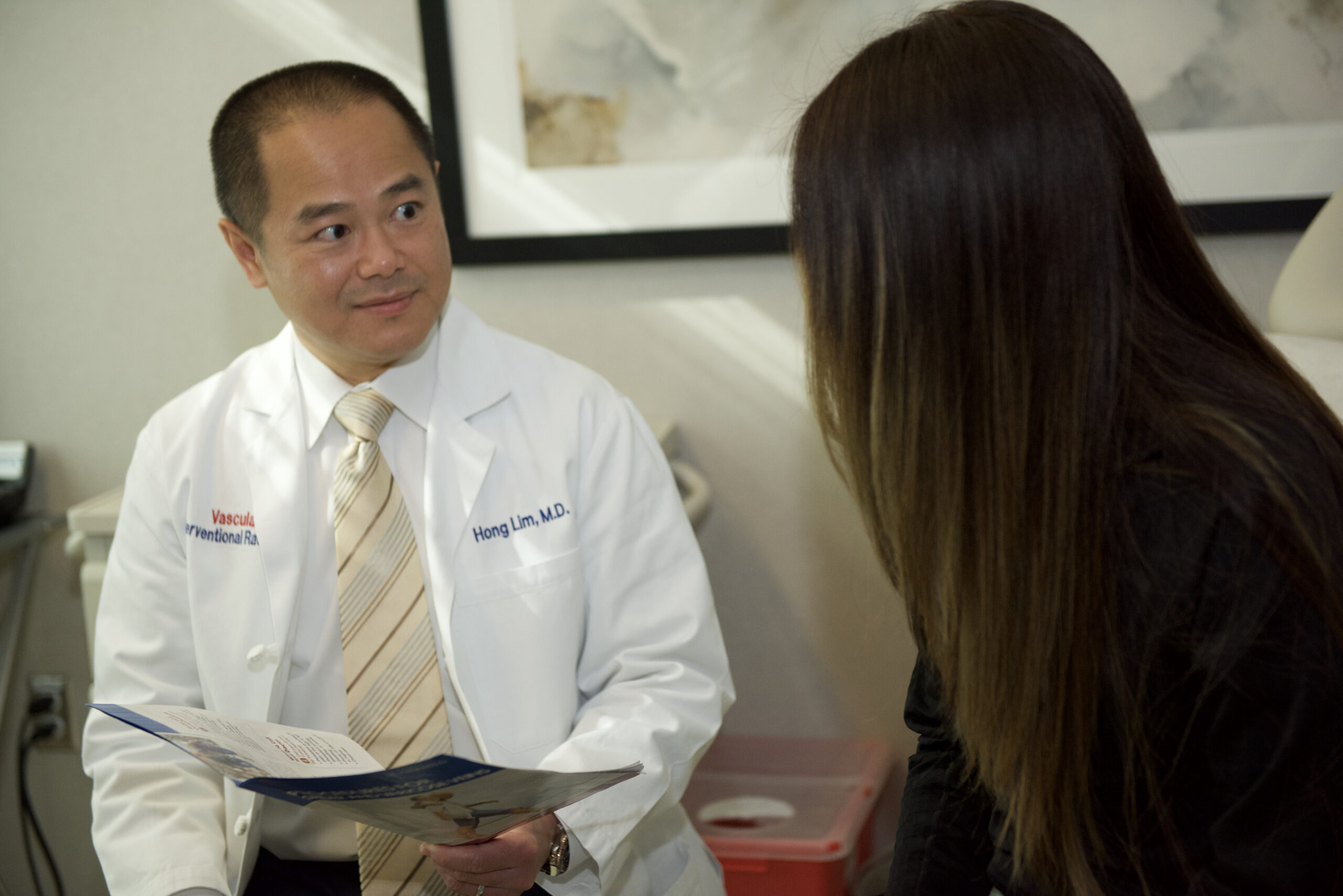 Interventional radiologist discussing non-surgical treatment of benign thyroid nodules with patient